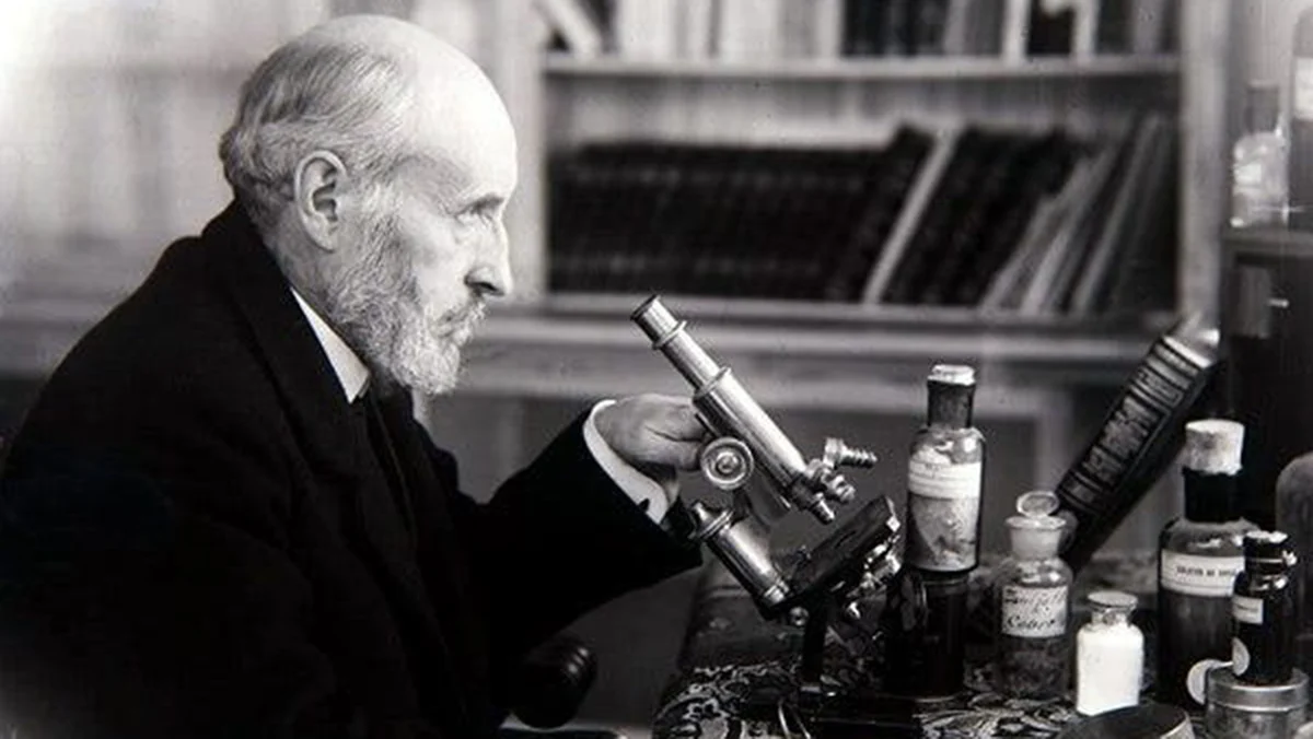 Santiago Ramón y Cajal en su laboratorio, posiblemente en Tarragona, observando al microscopio con concentración.